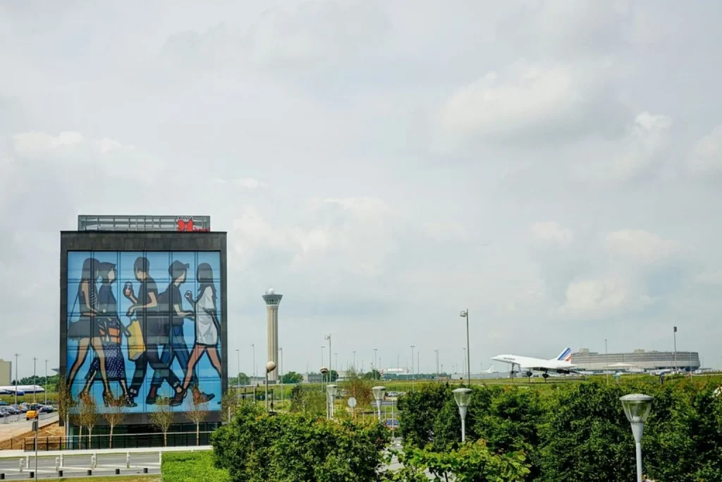 Exterior with the airport control tower and terminal in the background at citizenM Paris Charles de Gaulle Airport