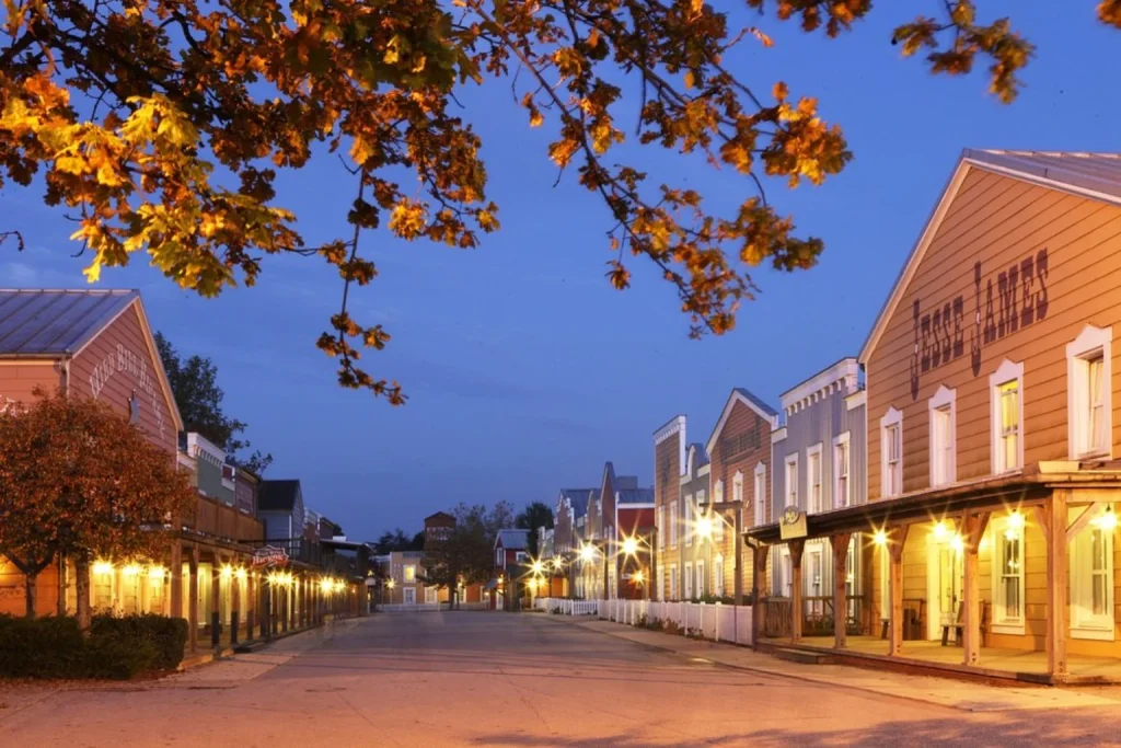 Wild West-themed hotel buildings and illuminated street at Disney Hotel Cheyenne, Disneyland Paris.