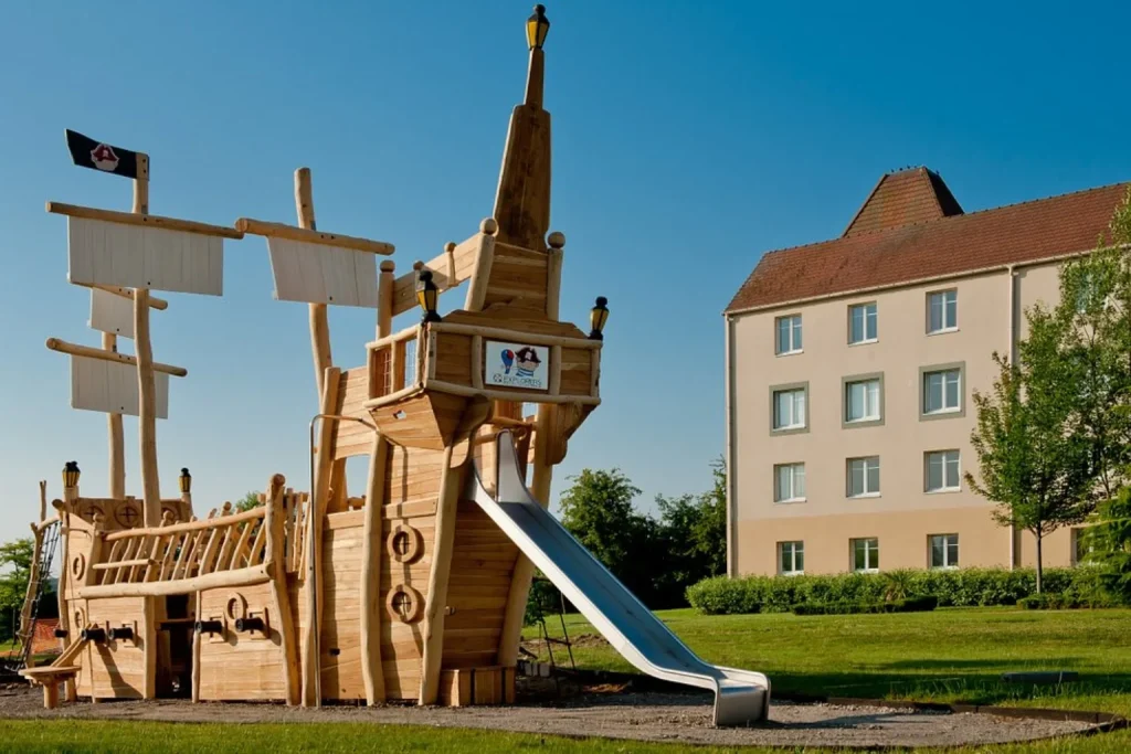 Pirate-themed outdoor playground with a wooden ship at Explorers Hotel near Disneyland Paris.