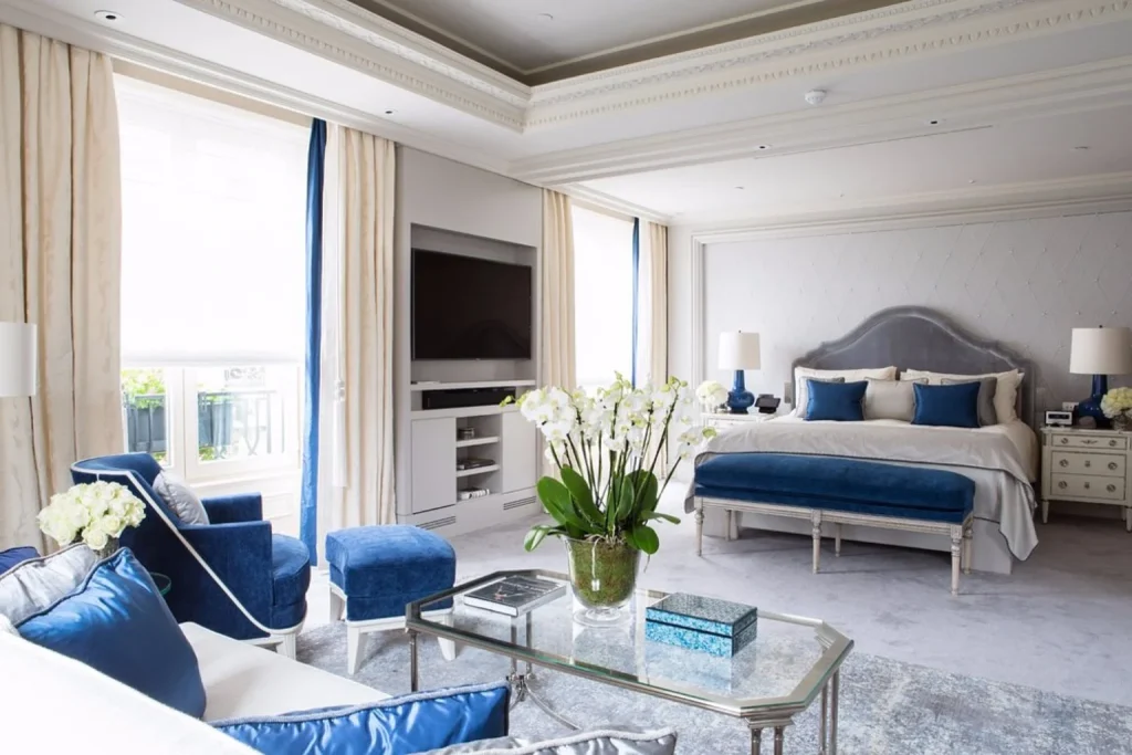 Elegant luxury suite with blue furnishings and spacious seating area at Four Seasons Hotel George V, Paris