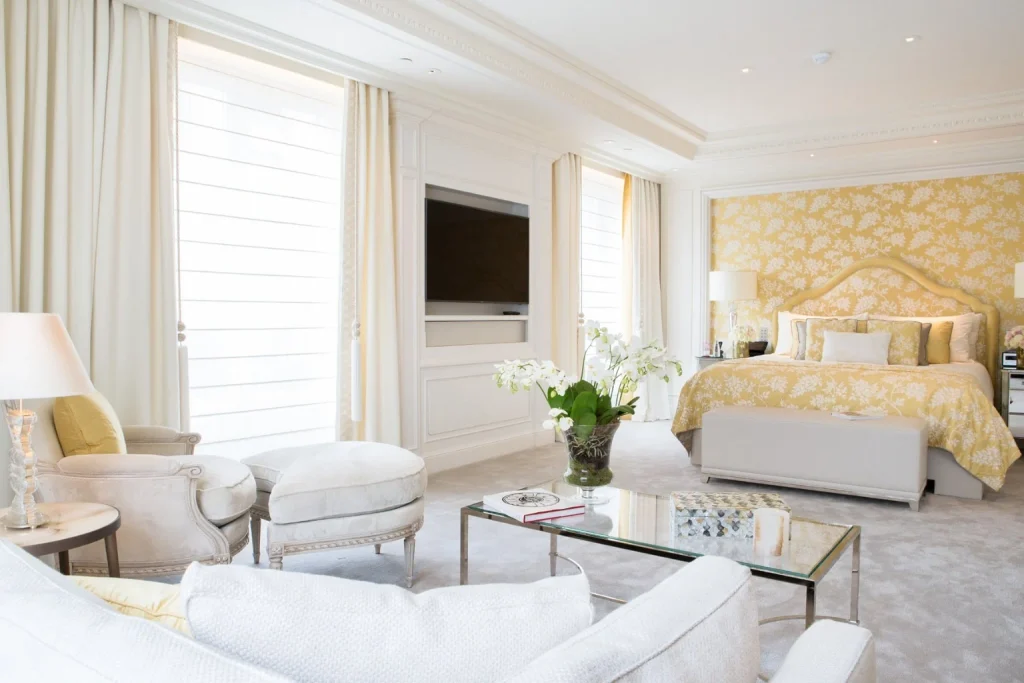 Bright and elegant luxury suite featuring a spacious bedroom and refined sitting area at Four Seasons Hotel George V, Paris.