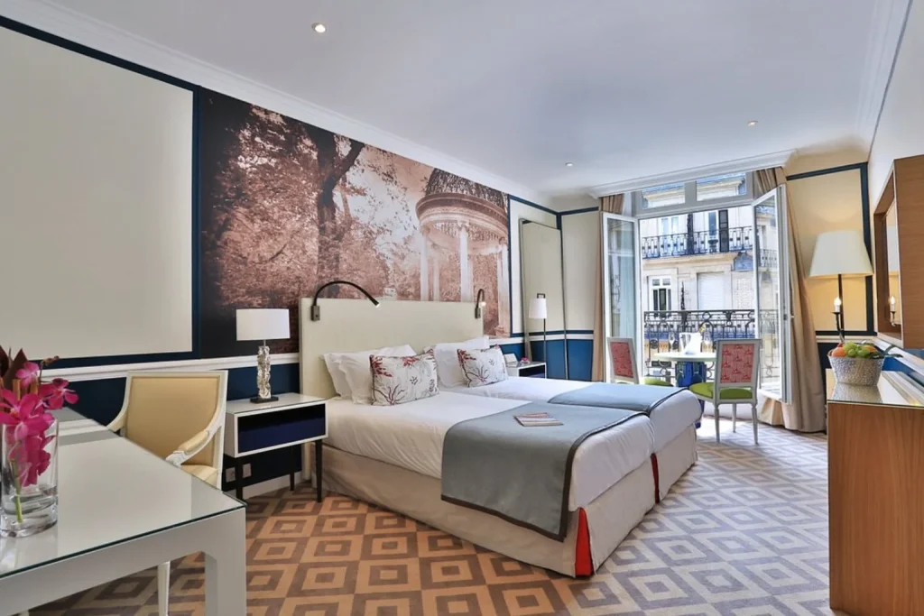 Elegant guest room with twin beds and large windows at Fraser Suites Le Claridge Champs-Élysées in Paris