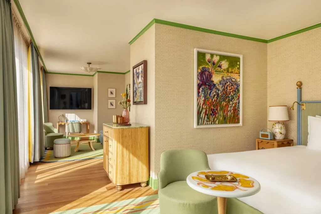 Colorful luxury suite with artistic décor and separate seating area at Hôtel La Fantaisie in Paris
