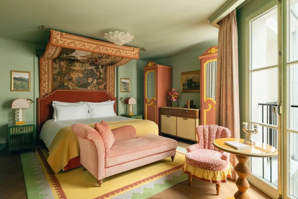Colorful luxury guest room with decorative canopy bed and elegant seating at Hôtel Le Grand Mazarin in Paris