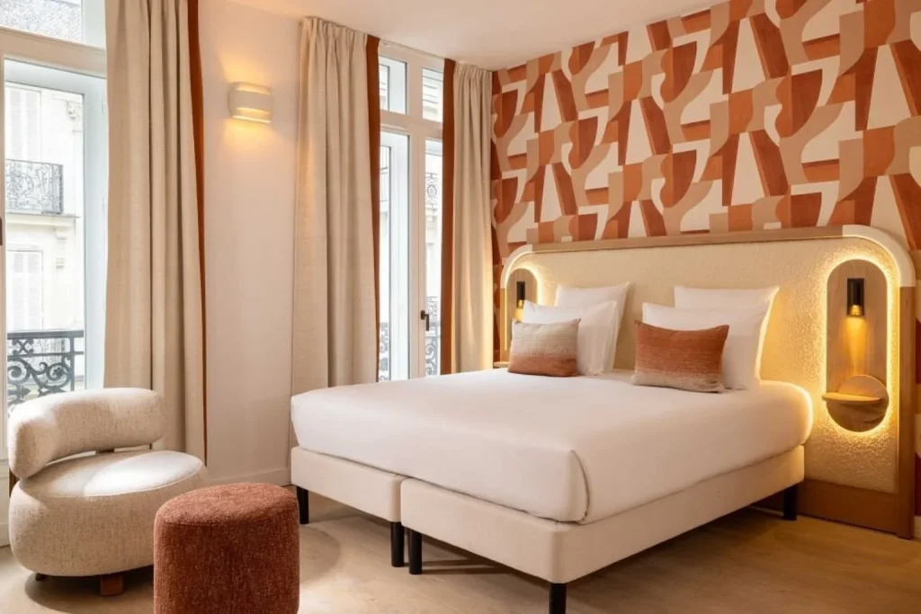 Bright guest room at Hotel Madame Drouot & Spa Opéra in Paris featuring warm geometric décor and contemporary furnishings.