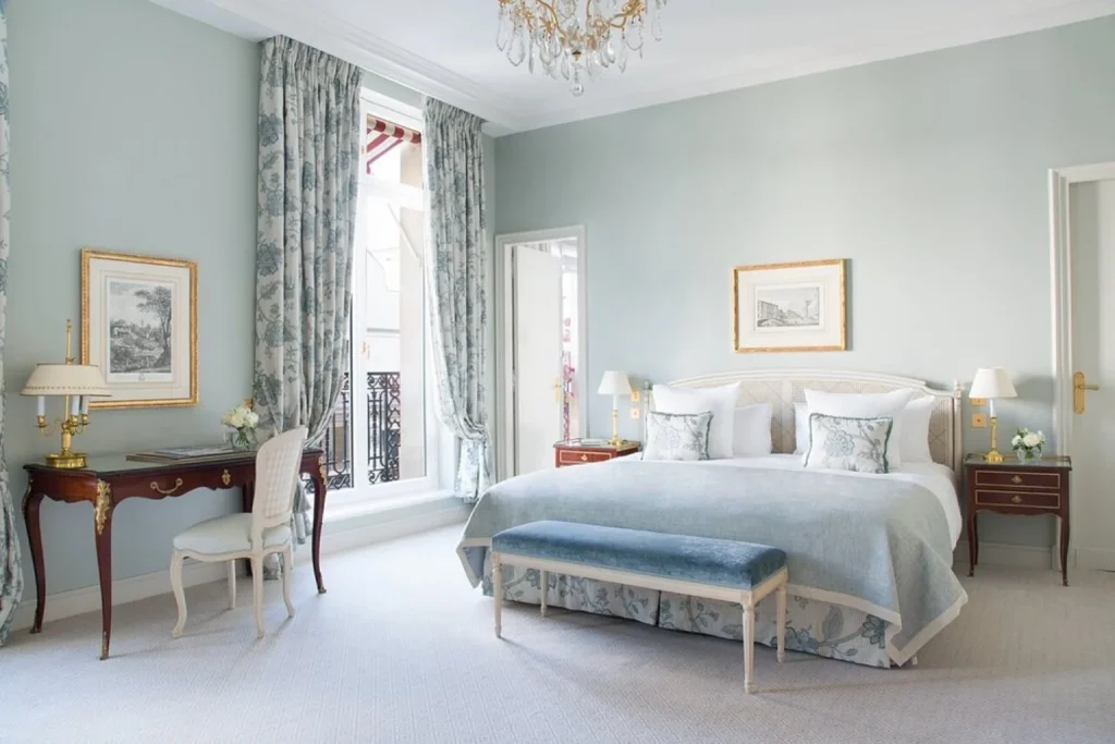 Elegant luxury guest room with soft blue décor and classic French furnishings at Le Bristol Paris