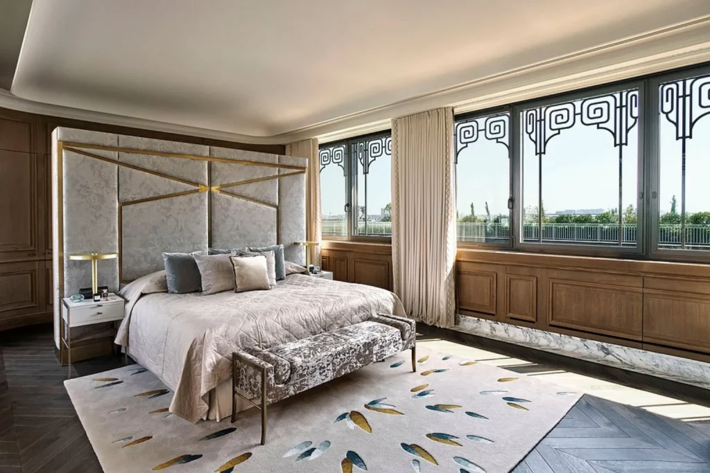 Elegant luxury suite bedroom with large windows and city views at Le Meurice in Paris