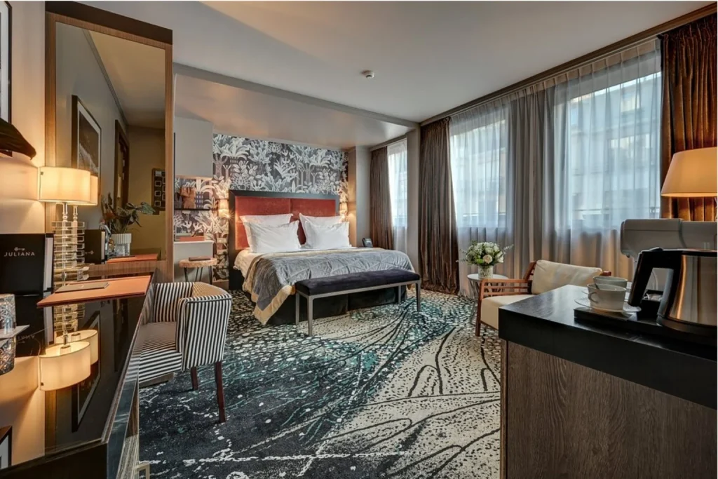 Elegant luxury guest room with contemporary furnishings and large windows at The One Alma Paris