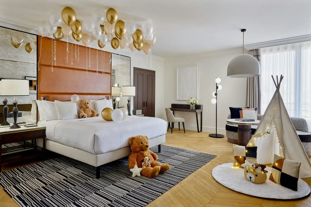 Family-friendly hotel room with a king bed, children’s play tent, teddy bears and balloons at Paris Marriott Champs-Élysées Hotel