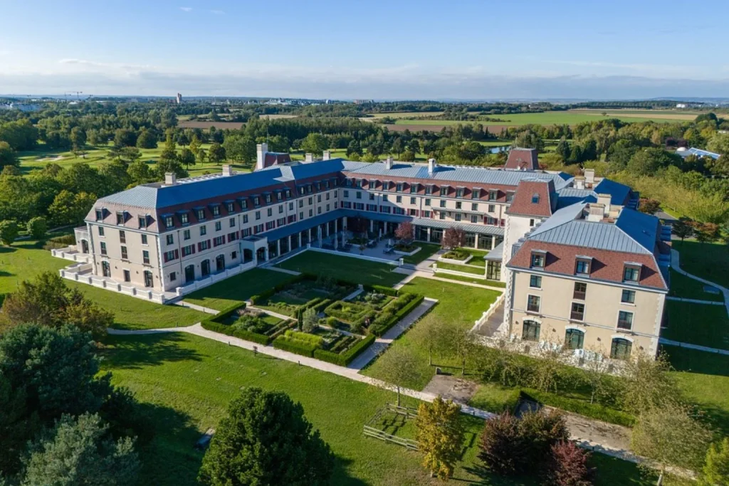 Aerial view of Radisson Blu Hotel Paris Marne-la-Vallée surrounded by landscaped gardens near Disneyland Paris.