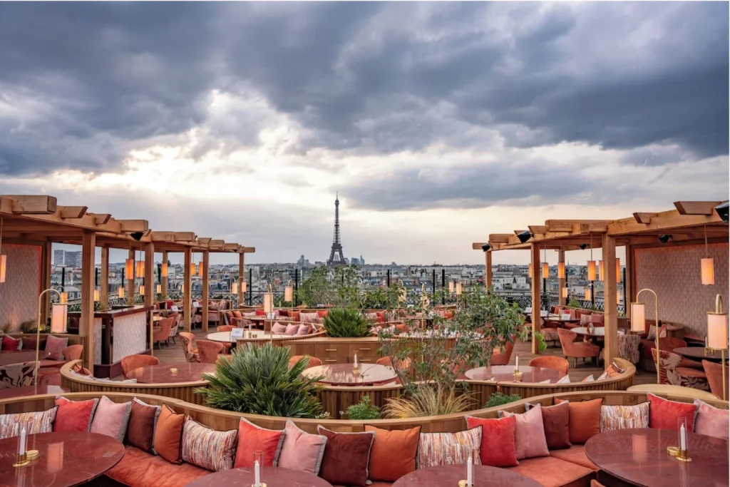 Elegant rooftop terrace with stylish seating and panoramic views towards the Eiffel Tower at Hotel SAX Paris.