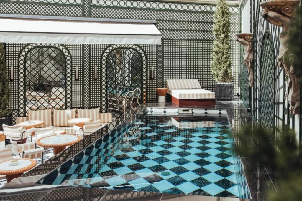 Outdoor swimming pool with elegant terrace seating at Sax Paris, LXR Hotels & Resorts in Paris