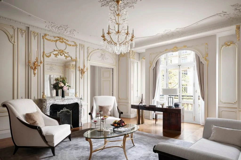 Elegant luxury suite living room with ornate French décor and crystal chandelier at The Peninsula Paris