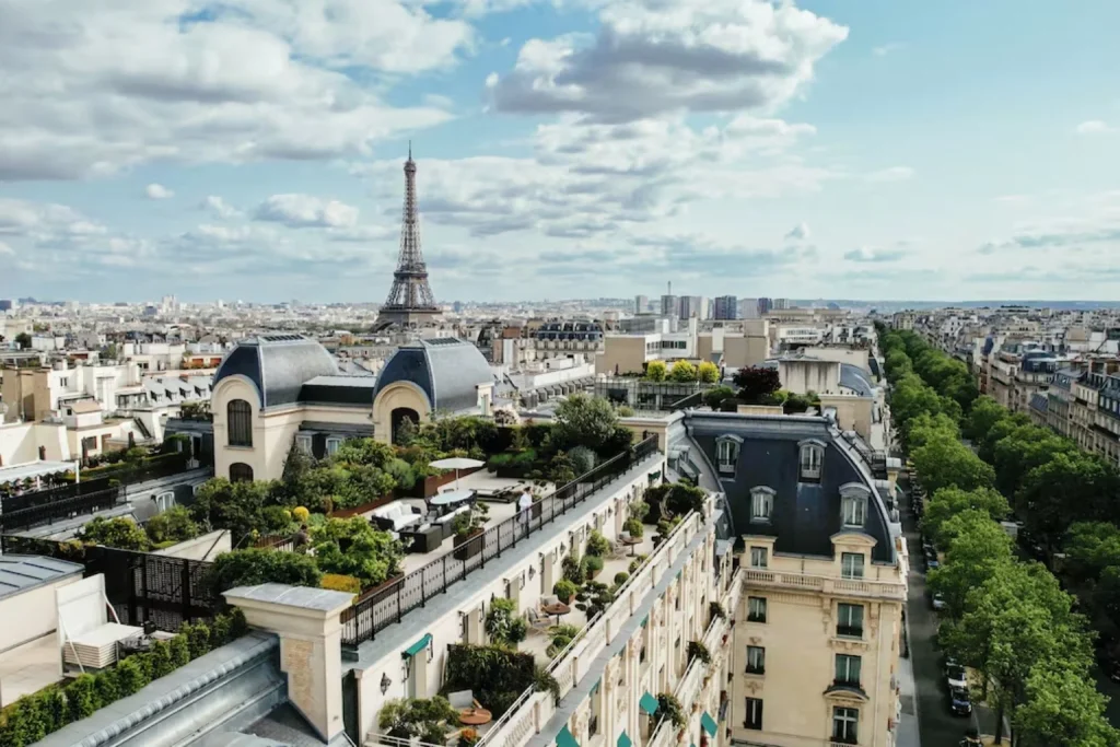 Sweeping panoramic view across the Paris rooftops, landscaped terraces and the Eiffel Tower at The Peninsula Paris.